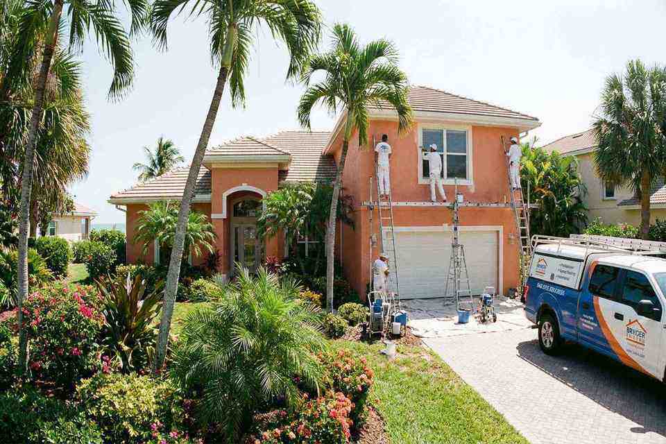 Exterior painters painting a coastal Florida home with professional equipment